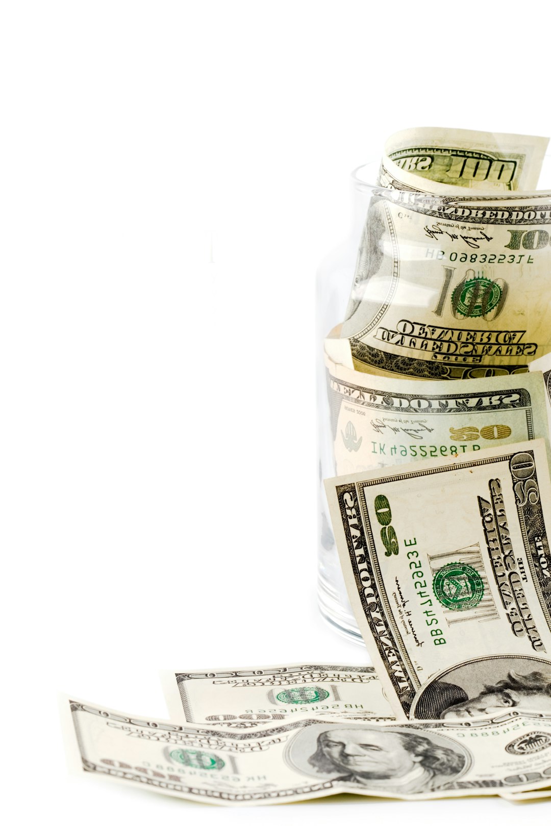 a-glass-filled-with-money-sitting-on-top-of-a-table-o1cdth4lr3w